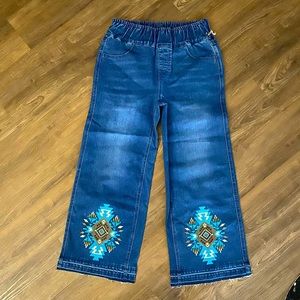 Pull on wide leg crop jeans with embroidery and raw hem.
